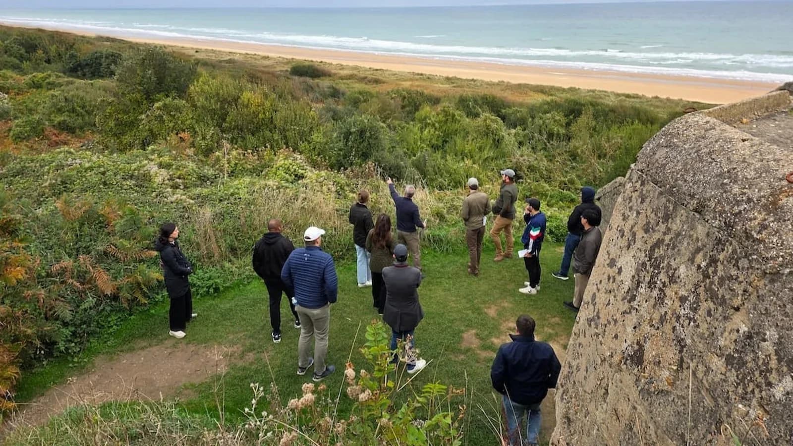 Dr. Brian DeToy of Essential History Expeditions leads a discussion with fellows at Omaha Beach, Normandy, France.